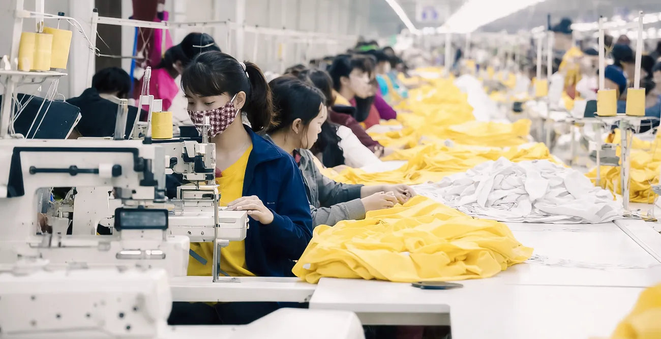 Large-scale garment production line in Bangladesh factory with workers and high-volume